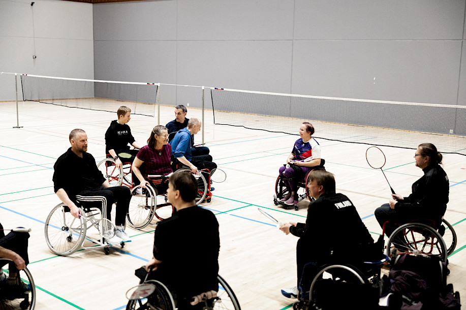 People having fun testing how badminton wheelchairs are used on the court.